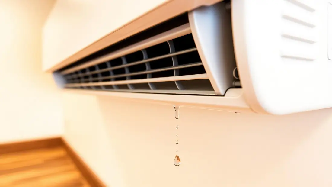 Water dripping from an indoor split AC unit onto the floor of a Dubai apartment